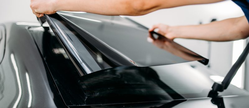 Male-specialist-with-car-tinting-film-in-hands-102798987-800x349